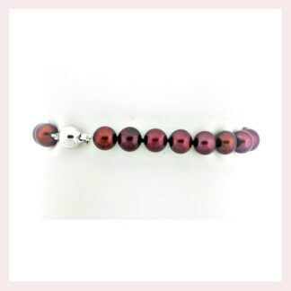 A burgundy pearl bracelet with a silver bead featuring a Chocolate Pearl Bracelet with 14KT Gold Clasp.