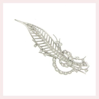 An Feather brooch with diamonds in 18KT white gold featuring a delicate leaf design.