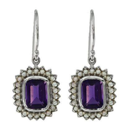 A pair of earrings with purple stones and pearls.