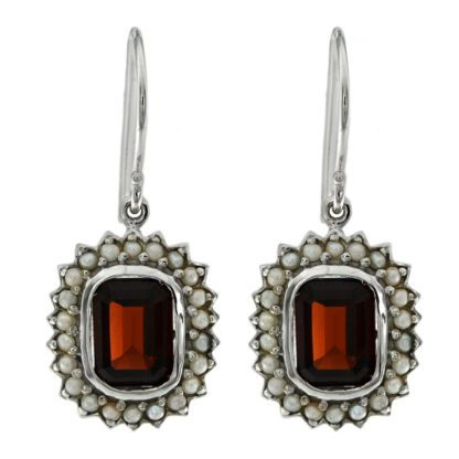 A pair of earrings with a garnet stone and pearls.