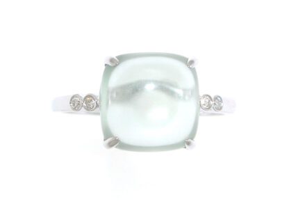 A ring with a green pearl and diamonds.